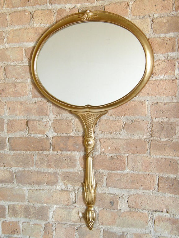 Whimsical, gilt metal wall mirror shaped like a giant hand mirror by Palladio, Italy. It's the perfect size for a petite vanity or bathroom mirror.

Please contact us if you have any questions.