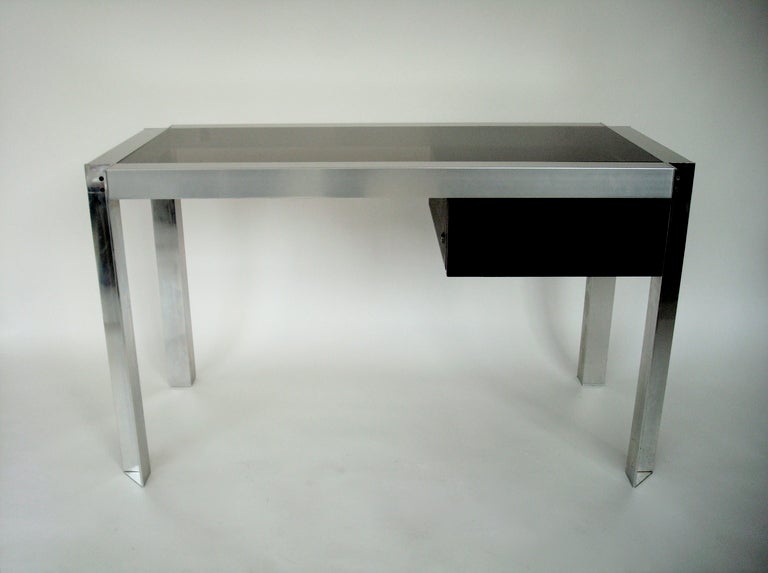 French 1970s nickel chromed steel and aluminium desk with smoked glass top. Single locking, ebonized oak drawer, with original plastic catch-all insert.
All parts original. 
Designed by Etienne Ferminger and edited by the French design house Kappa