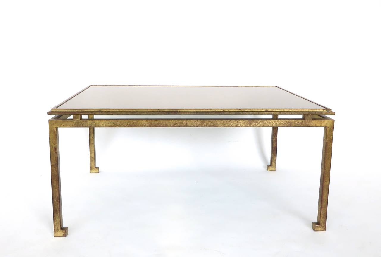 Maison Ramsay superb patina gold leaf wrought iron rectangular coffee table with a lightly tinted pale bronze tone mirror top. Beautiful Classic French Maison Ramsay iconic design with wonderful patina. Slight Asian motif references.