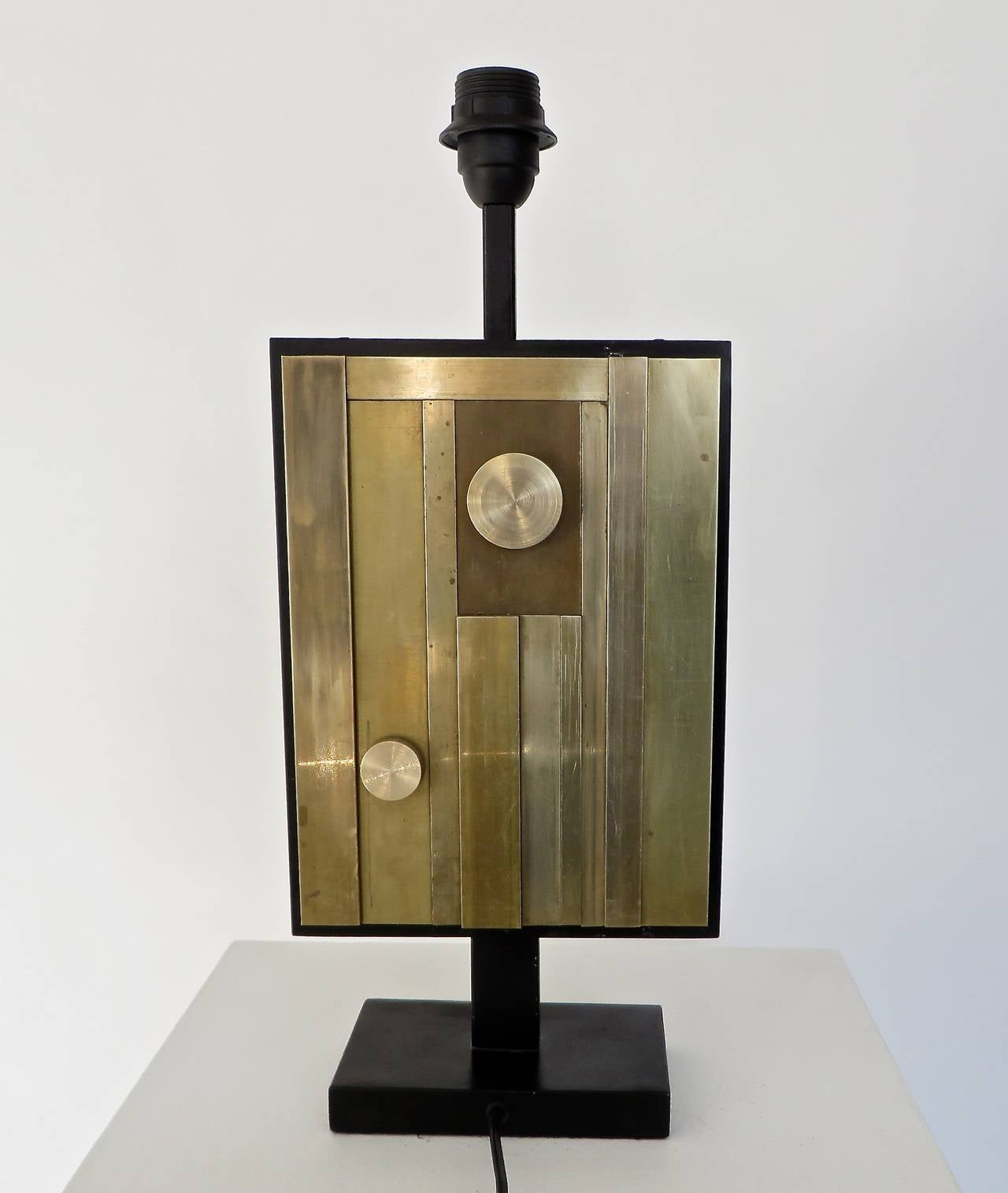 Pair of Italian composed cubist patterned Industrial brass table lamps in black metal frame on black metal bases with oversize black linen shades. Each lamp has a different composition on the front and identical composition on the back. Composed of