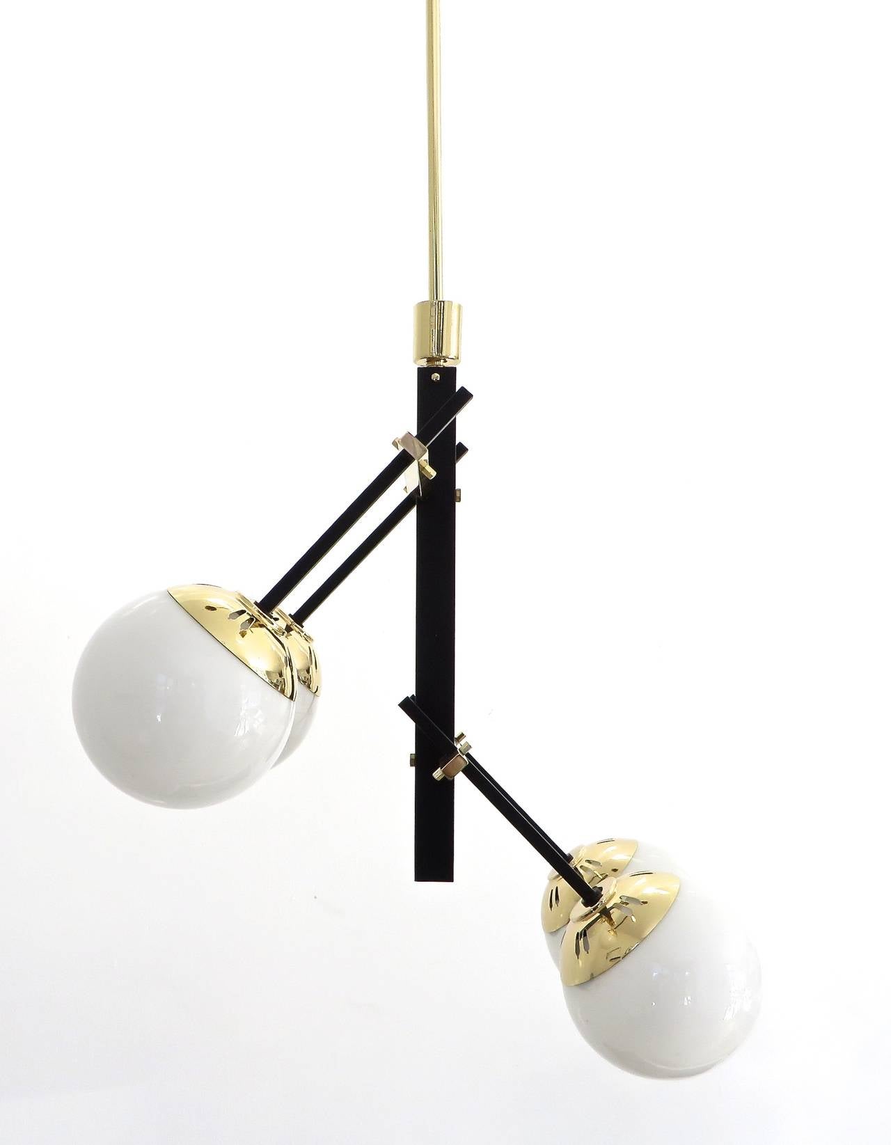 Asymmetric Italian brass, black lacquered brass and glass globe chandelier by Stilnovo.
The Stilnovo look includes large use of black stem and rods and polished brass elements.
Measurement is as shown size, each globe is 5