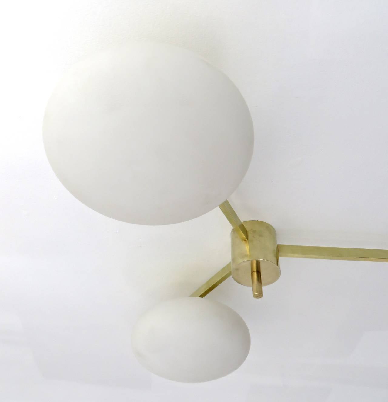 Angelo Lelli three-arm ceiling light or wall light or sconce for Arredoluce, Italy, circa 1950. Two available 
Original patina. Signed with makers mark to finial.
Brass with opaque glass shades. Shown in detail shot with original sockets. 
Now