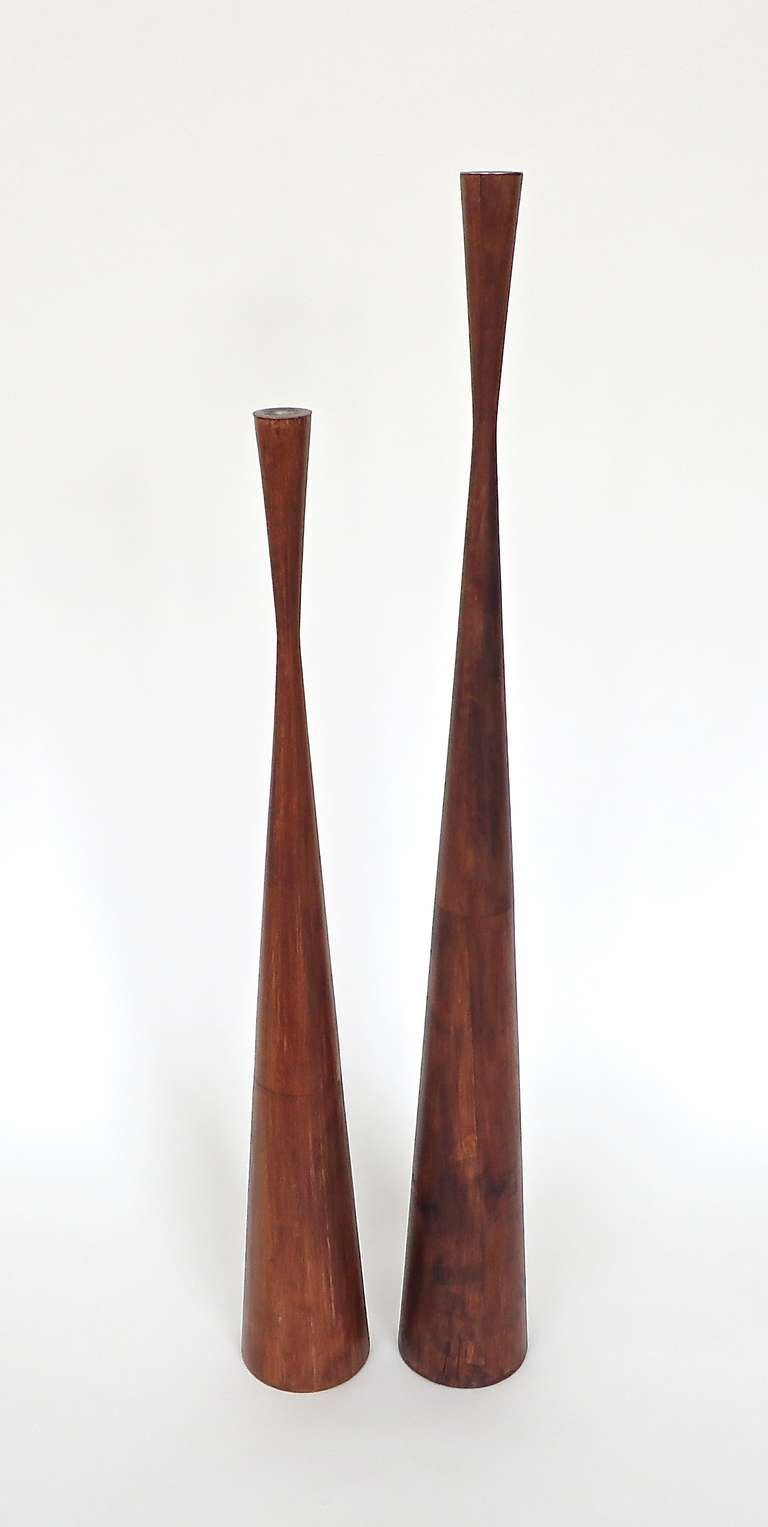 Pair of very exceptionally elegant and sculptural, tall Danish candlesticks, lathe-turned teak, with aluminum liners. 
Attributed to Dansk.
Taller Candlestick: 37.5