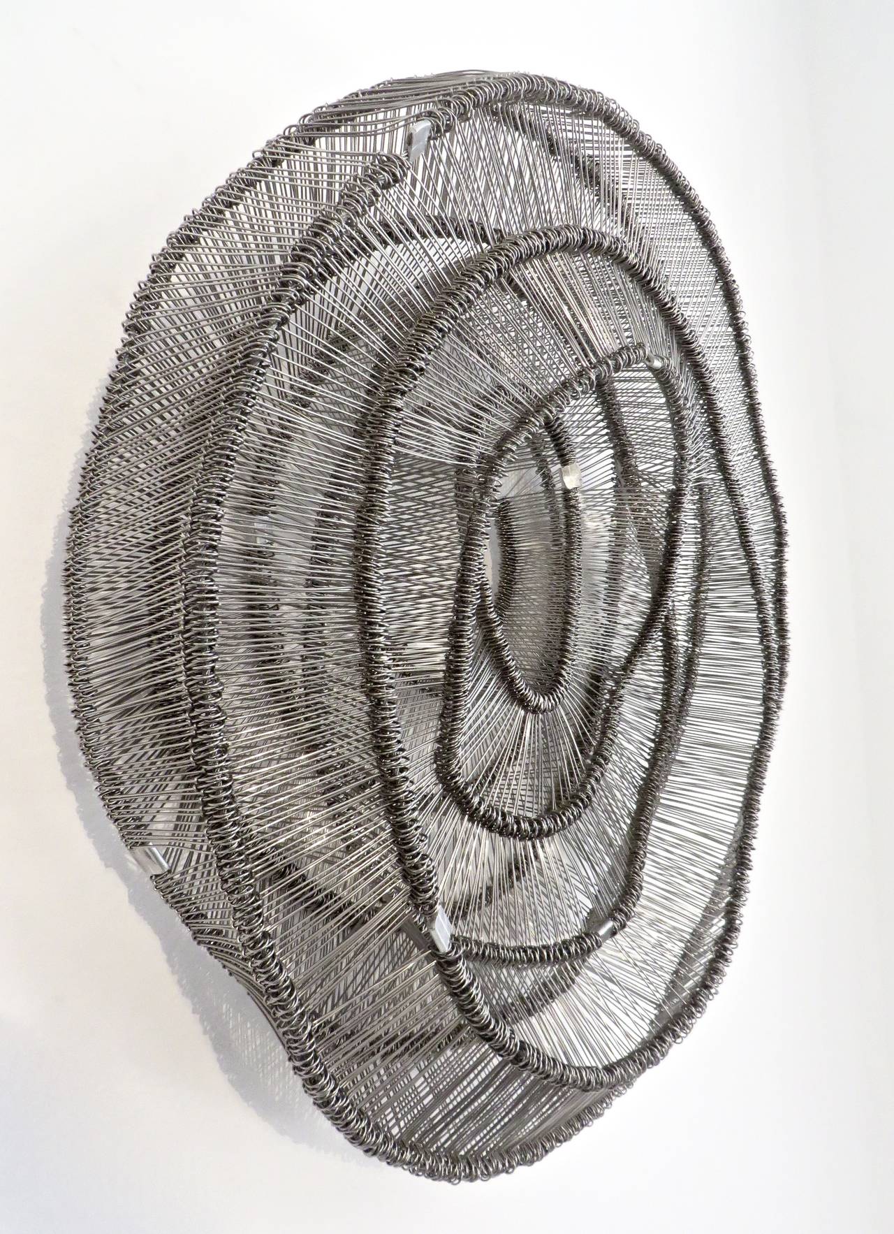 Eric Gushee Emergence Series No. 1 Stainless Steel Woven Metal Sculpture. 2015
From the exhibition: Product of the Moment at Pavilion.
Asymmetrical woven metal sculpture for the wall. 
Eric Gushee, is an artist living and working in Chicago.