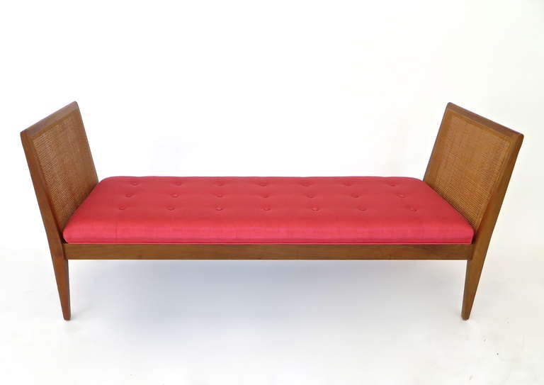 Excellent condition mahogany upholstered and caned sided bench. Very streamlined profile. By Paul McCobb.
