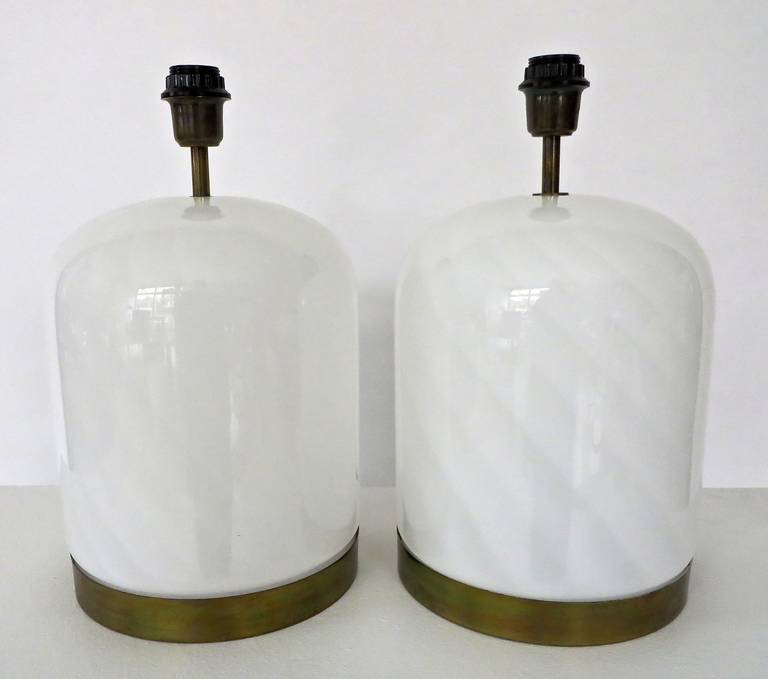 A beautiful pair of large white Vistosi Murano table lamps with two-toned white swirl motif with the base banded in brass. Nice patina on the brass. 
Shown without shades and original Italian sockets. 
Perfect condition to the glass, no chips or