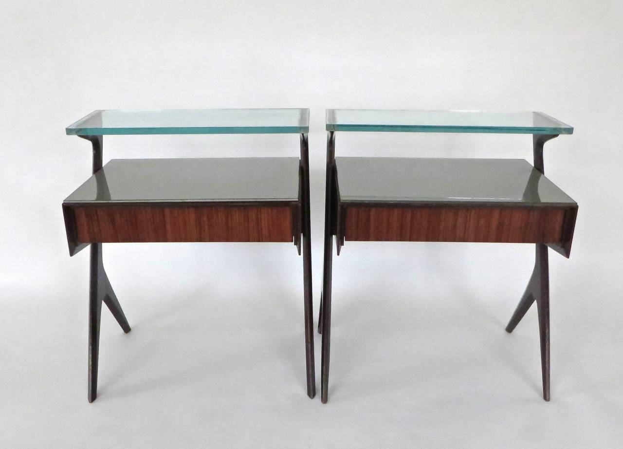 Pair of side tables or bedside tables attributed to Ico Parisi. 
Two level, wood and glass tables with drawer.
Beautiful original, deeply etched glass .5 in thick plateau grooved to inset on mahogany side structure. 
Second original glass plateau