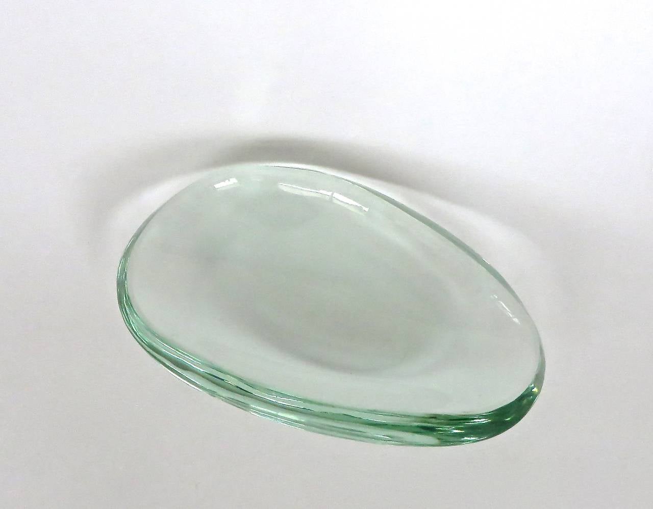 Italian elongated oval glass dish or vide poche by Fontana Arte. Iconic thick glass in excellent condition. Some evidence of use on bottom of dish.