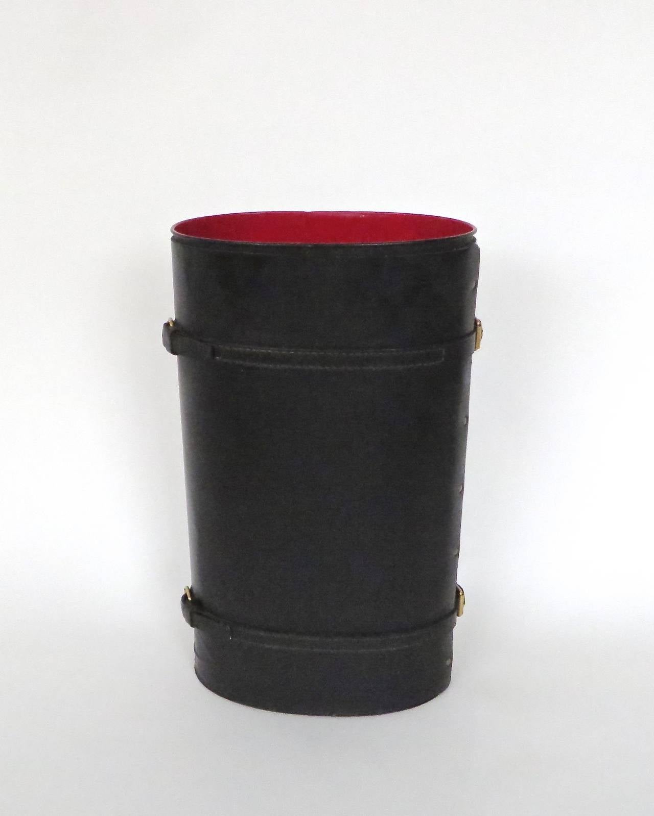 Tall French black leather with red interior oval umbrella stand by Jacques Adnet. Two leather and brass buckles, circa 1950.