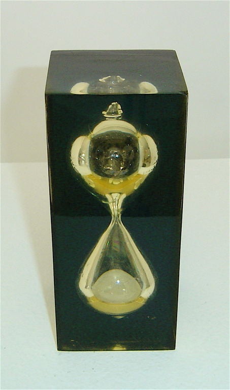 Handblown hourglass sand timer imbedded in pale yellow and black resin.