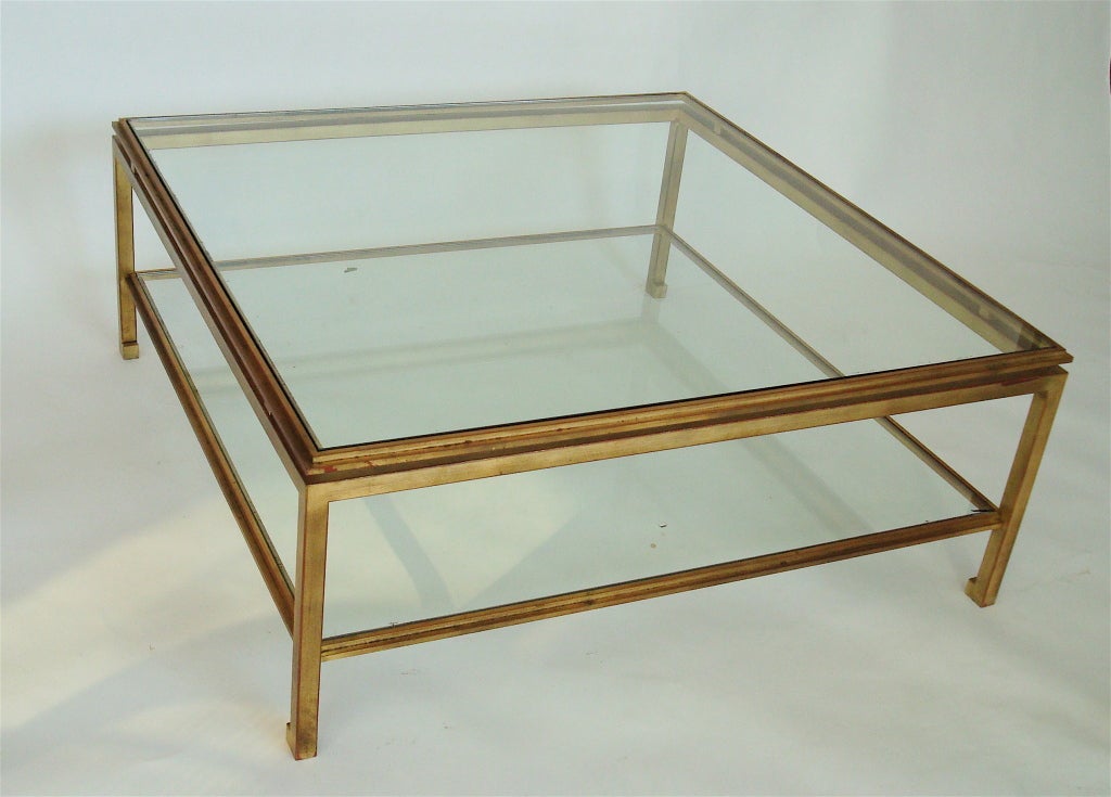 Gilded iron very chic coffee table by Guy LeFevre for Maison Jansen. Excellent patina on the gilding. Two clear glass plateaus. Bottom shelf 5.5