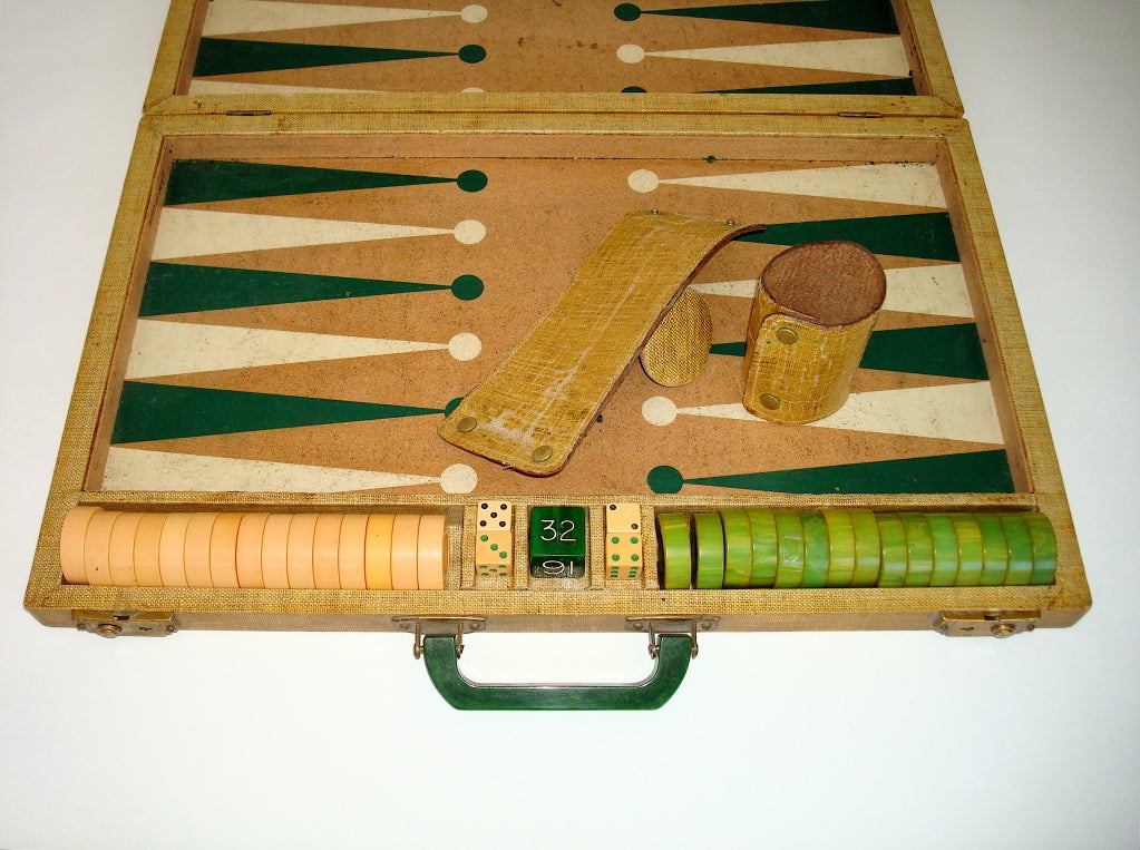 Fantastic, complete Backgammon set with all Bakelite pieces with the original folding grass cloth dice shaker cups. A Bakelite handle with brass locks on the grass cloth carrying case. <br />
open 25