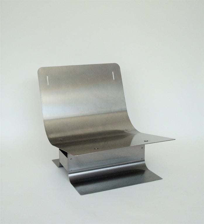An iconic and very chic, low pair of stainless steel chairs, by Francois Monnet, French c 1970. Ready for reupholstery. The cushions are excellent but fabric is ready for a change.