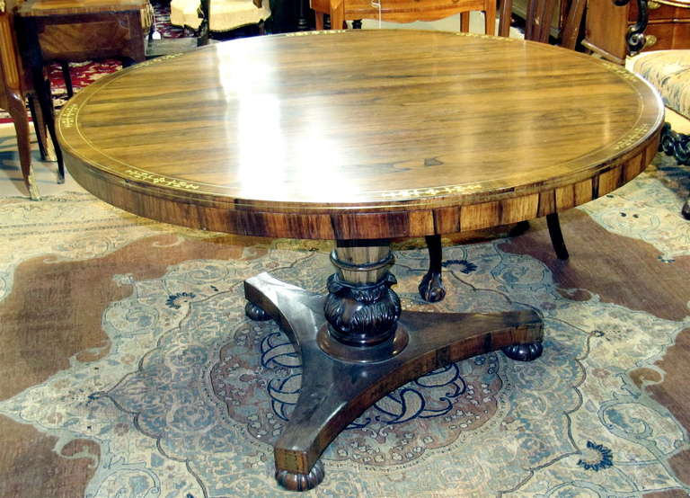 Exceptional Regency calamander breakfast/center table with brass inlay. Circular top inlaid to show foliate forms, raised on a faceted and foliate carved standard over a tripartite base with melon feet.