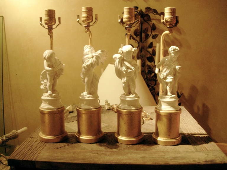 Charmant ensemble de quatre figurines de quatre saisons en porcelaine montées comme des lampes.