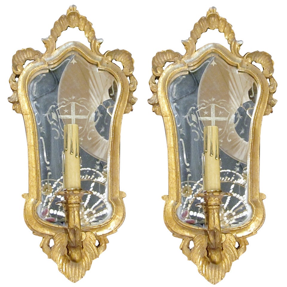 Une paire d'appliques italiennes en bois doré avec support en miroir