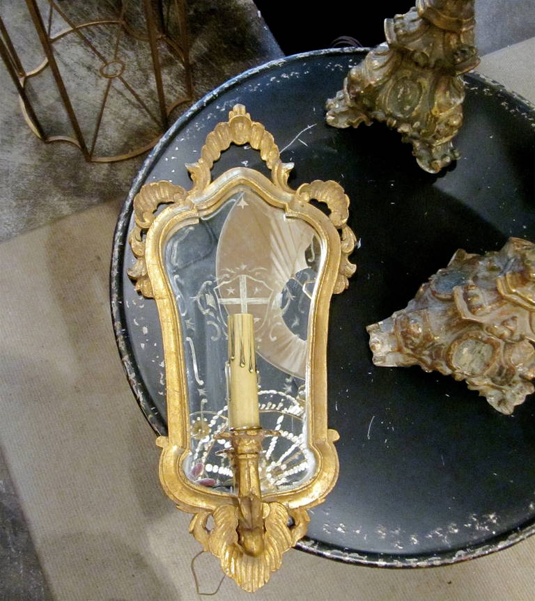 One pair of Italian giltwood sconces with mirror backing, armorial etching on mirror, newly rewired.