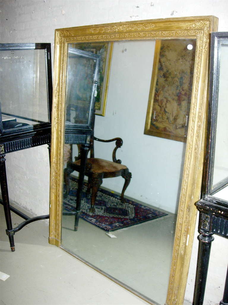 Miroir trumeau en bois doré de style Empire, 
19e siècle, la plaque verticale rectangulaire dans un cadre décoré de vignes et de rosettes.