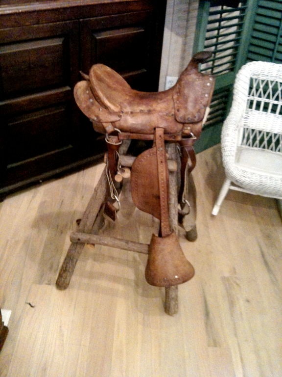 Charming antiques childs saddle mounted on later rustic stand.