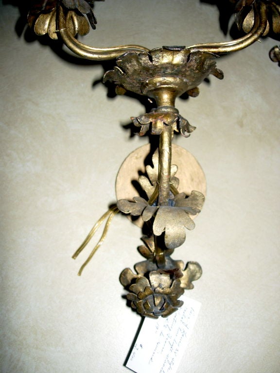 Une paire d'appliques à deux lumières en métal doré de style Louis XV, chacune de forme florale stylisée.