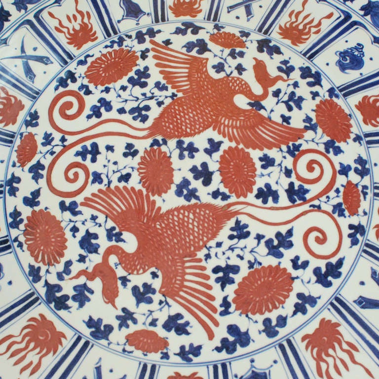 A grand platter with blue and red details. The platter is painted with double gourds, flowers, and two large phoenix. 

Pagoda Red Collection # ZZZ089