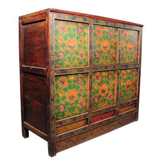 A 19th century Tibetan four door cabinet painted with flowering lotus and vines.