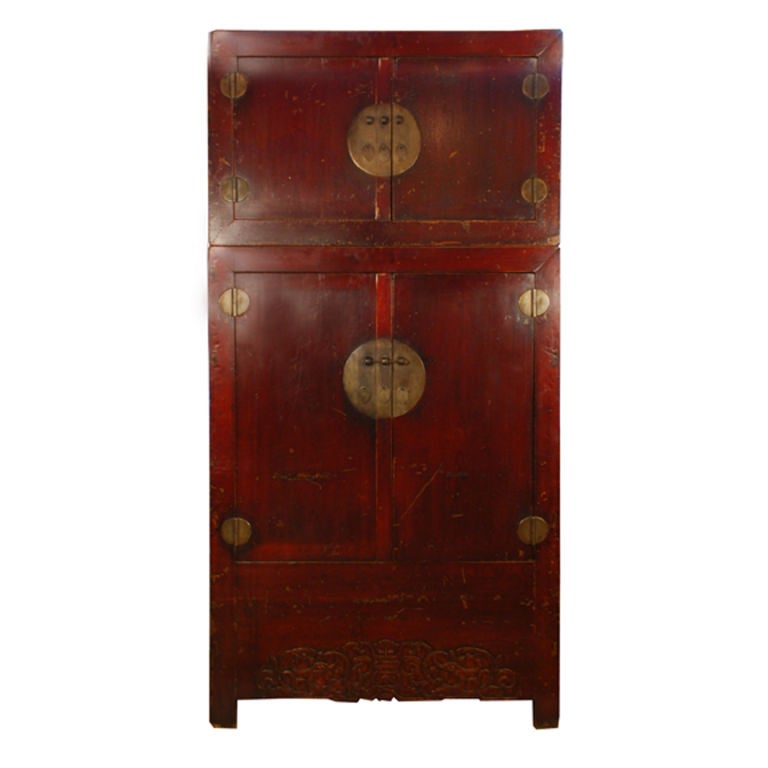 A 19th century Chinese elmwood compound cabinet with brass hardware, dragon carved apron and a rich oxblood lacquer finish.