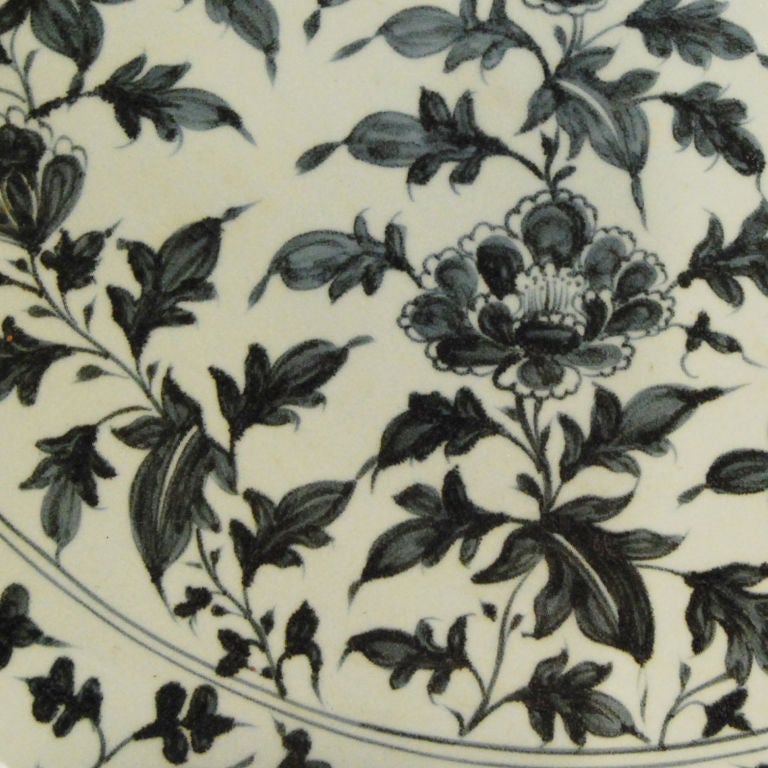 A monumental porcelain underglazed platter depicting flowering lotus and vines with scalloped edge.