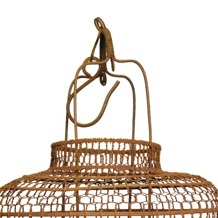 An early 20th century Chinese wire cage lantern with wooden base.<br />
<br />
Pagoda Red Collection #:  LAA011B<br />
<br />
<br />
Keywords:  Lantern, chandelier, light, pendant, sconce