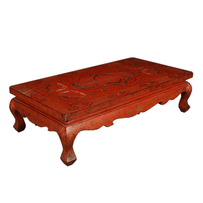 An early 20th century Chinese red lacquered kang table with ornately painted top depicting the Shou character and other auspicious flowers and symbols.