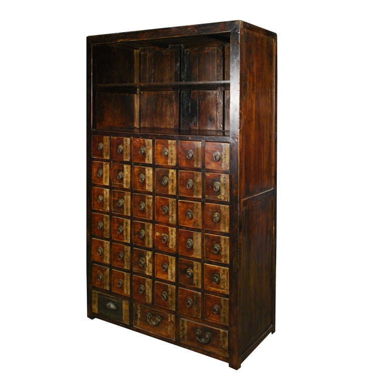 A tall apothecary cabinet from China made of Northern Chinese Elm. This cabinet features thirty-nine drawers and two upper shelves.
