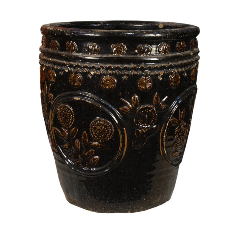 A 19th century Chinese glazed ceramic jar with floral relief.
