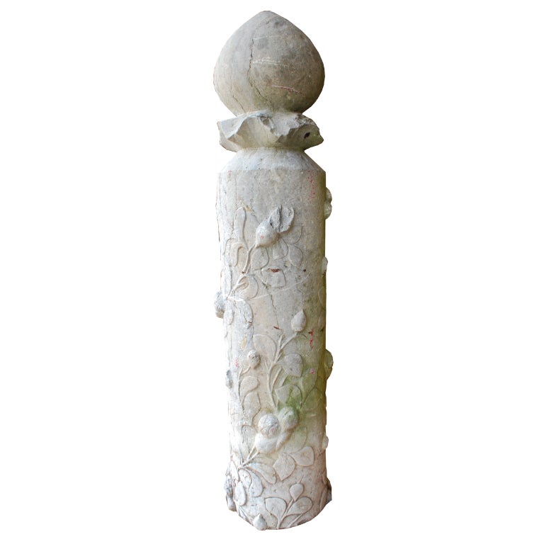 An 18th century Chinese carved limestone garden post depicting flowering peonies around the base with a lotus bud finial.