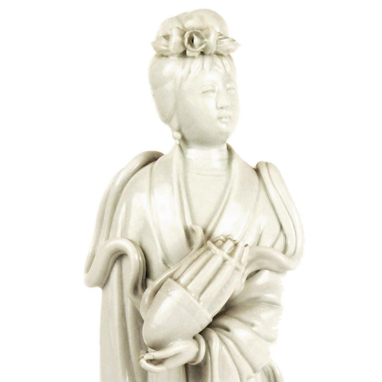 An early 20th century Chinese porcelain Blanc de Chine figure of Guanyin holding 