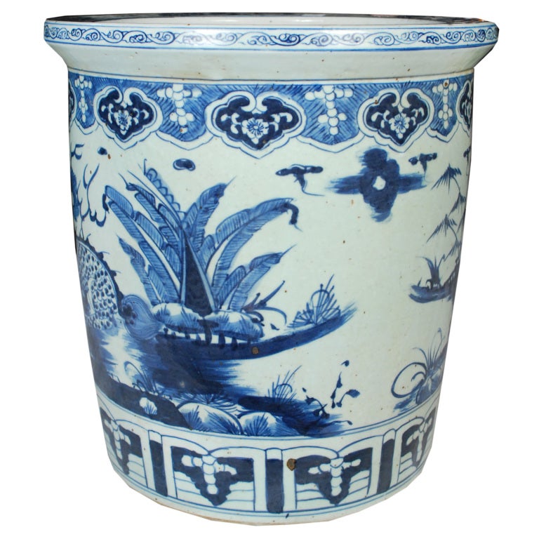 A hand-painted blue and white porcelain scroll jar showing lions in a landscape scene.