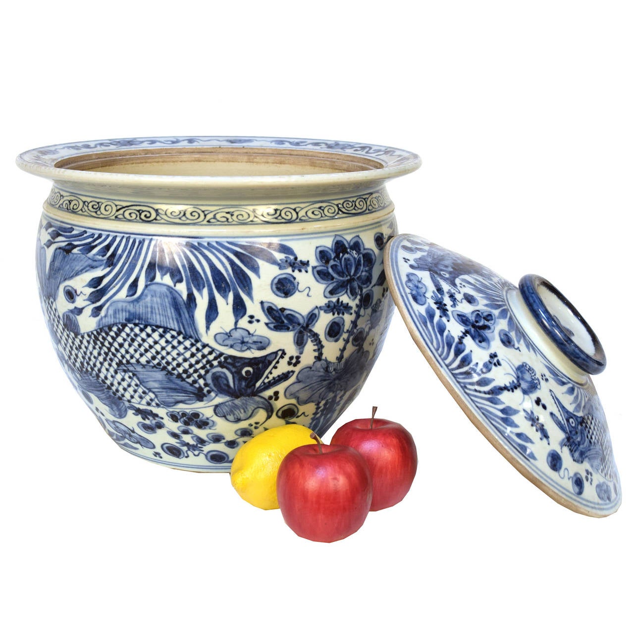 A wide mouth blue and white jar with a lid from Beijing, China with a painted a fish motif.

