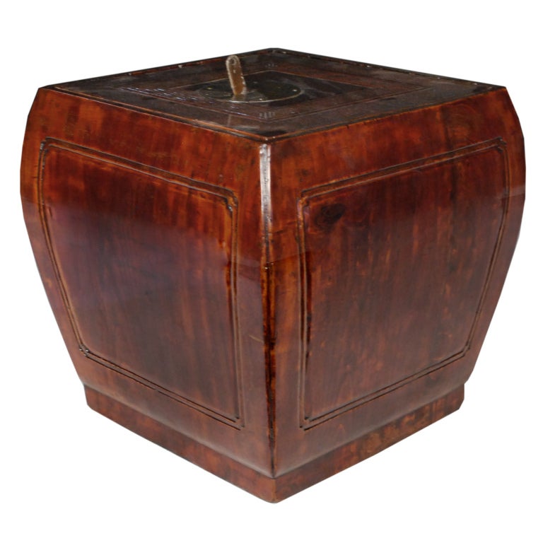 A 19th century Chinese elmwood convex-form low stool with lid carved with meandering motif and brass escutcheon. 