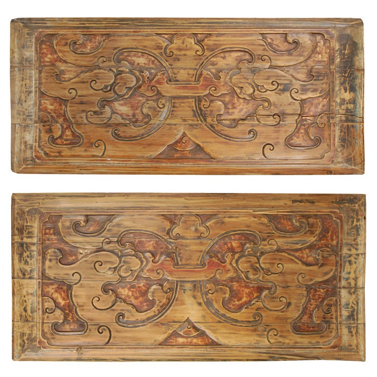 A 19th century Chinese elmwood panel carved with swirling dragons.