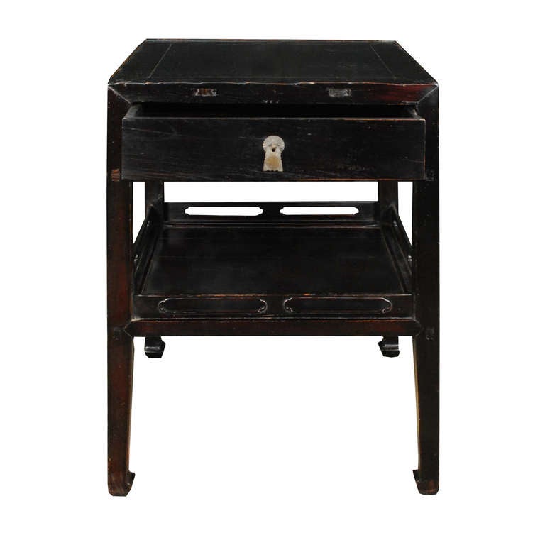 An early 20th century Chinese elmwood table with one drawer with brass hardware, and a shelf with pierced gallery.

Pagoda Red Collection #:  BJB020

Keywords:  Table, side, end, center, pedestal, nightstand, bedside