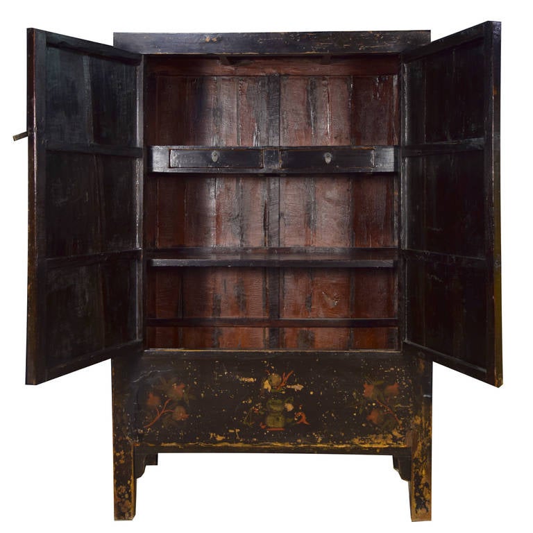 An exquisite black lacquer wucai, or five color, cabinet from Shanxi Province, China. This circa 1850 cabinet is painted with floral vases and scholars' objects. The two doors open to reveal two shelves and two drawers.