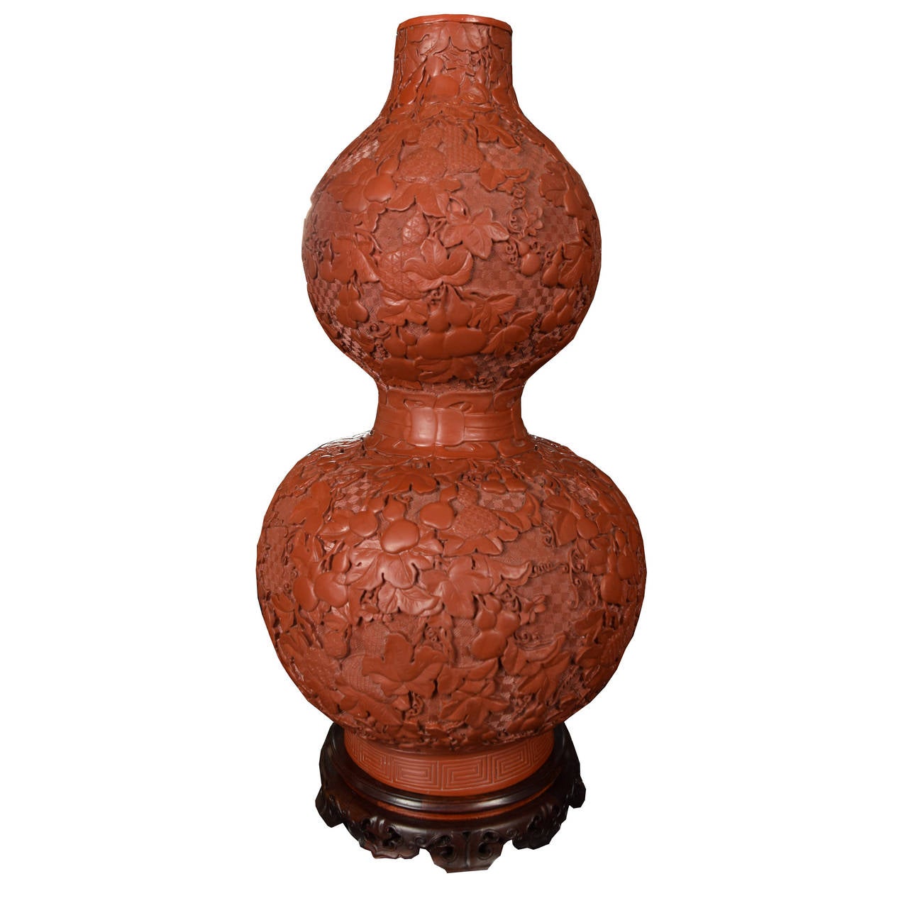 A tall pair of lacquer vases from China in a double gourd form. Each vase is carved with a gourd and vine pattern and sits atop a hardwood stand. 