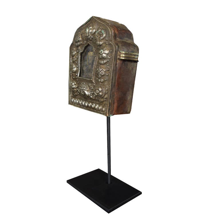 A 19th century Tibetan Gau, also known as a prayer box or traveling shrine. Brass on a custom stand. Traveling shrines were used to hold and carry sacred objects and were often believed to offer protective powers.