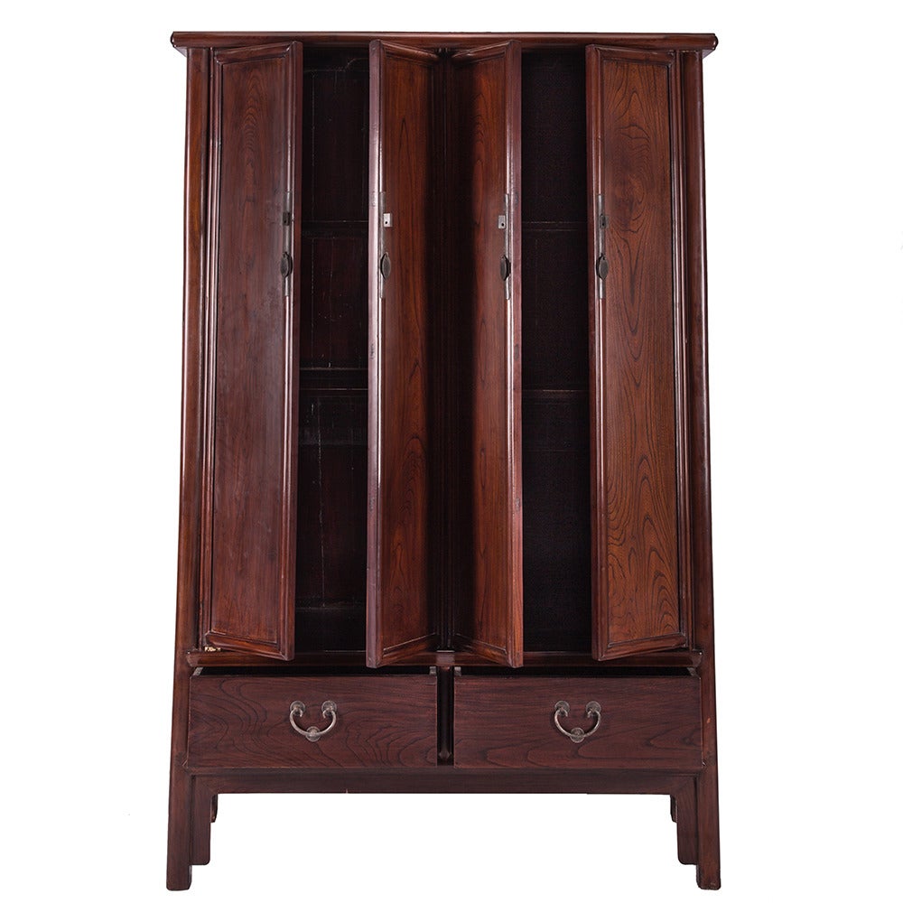 A four door and two drawer tapered cabinet from China. This c. 1600 piece is made of Beechwood and features high legs and rounded corners.