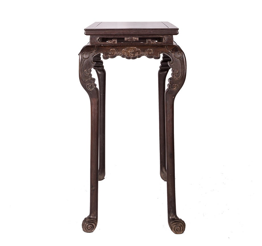 An early 20th century zitan wine table from Beijing, China with scrolling vine carving and legs that end in scrolled ball feet.