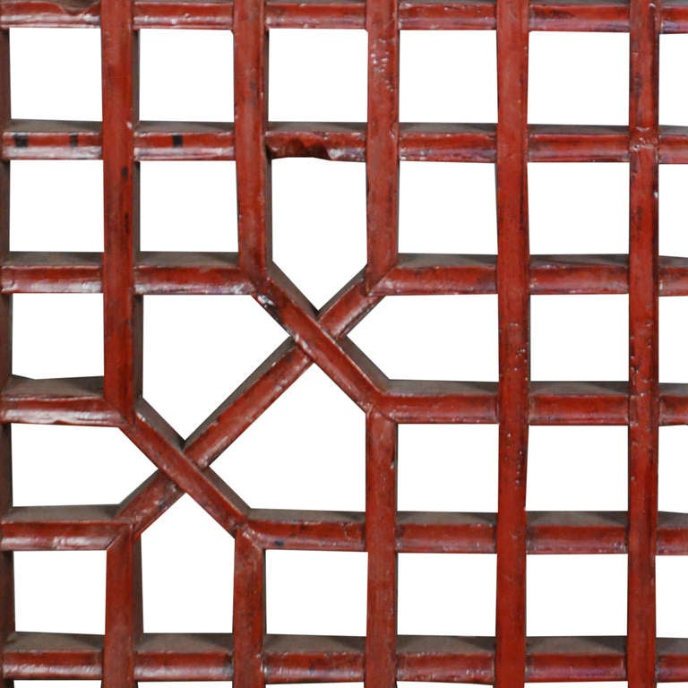 A red lattice panel from Shanxi Province, China. This circa 1900 panel is made of Cypress and painted red.