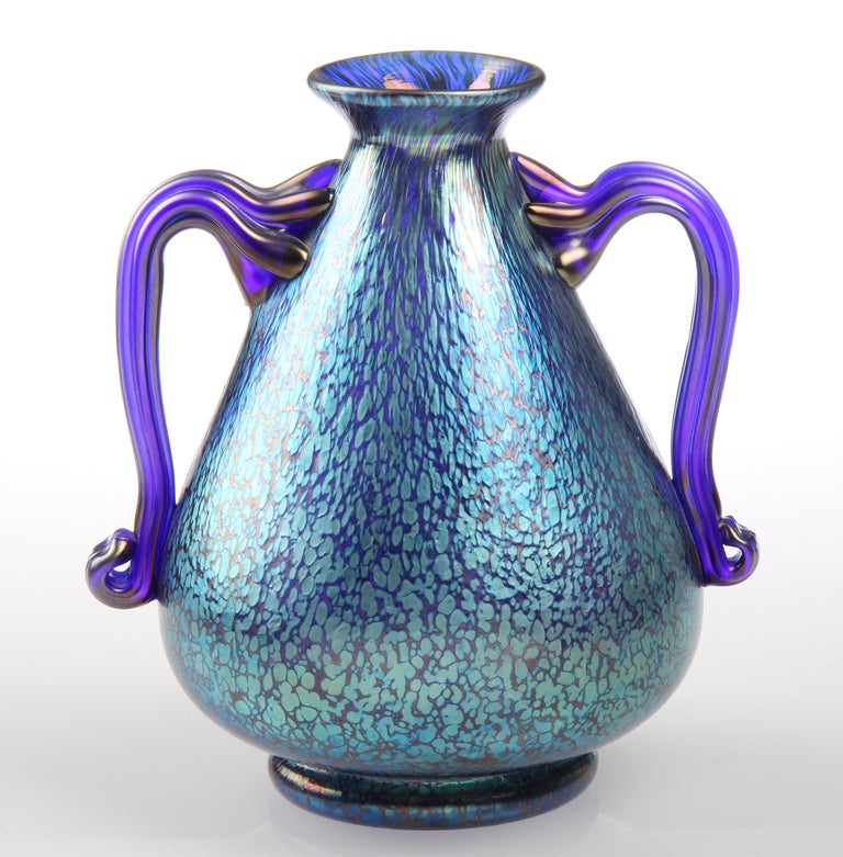 This is an  exceptional Loetz vase in iridescent blue colors.
Two opposing handles that are beautifully formed in a cobalt blue.
This vase has great presence and is finished with a polished pontil.
Marked on the bottom in oval, CZECHOSLOVAKIA