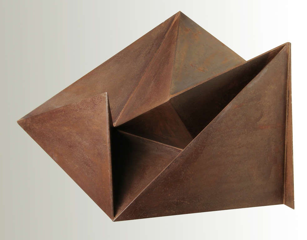 This is a handsome and visually interesting sculpture, Oragami like in appearance, the "folded"steel is a play between positive and negative space. The series it is from is called "Triangolare" as all the pieces are triangular in