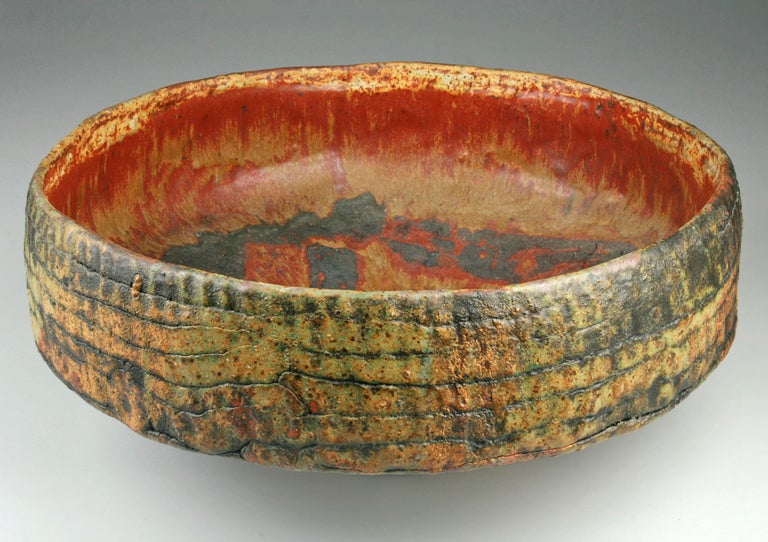 This is an impressive hand coiled bowl with glazes in green, golds and earthy reds by Ruth Duckworth.