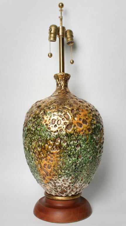 This lamp has a very interesting glaze. The colors are pumpkin, white, green and are highlighted with gold.