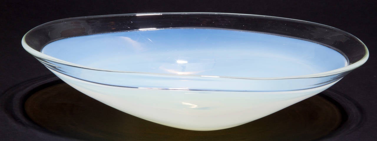 This unusual bowl is oval in shape with an opaline to clear glass body.
The glass captures the light beautifully.